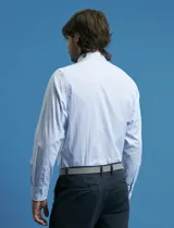 Camisa de corte clásico confeccionada en tejido oxford, con diseño de rayas verticales en tonos azul y blanco. Presenta cuello abotonado, cierre frontal con botones y bolsillo en el pecho con detalle de etiqueta bordada.