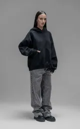 Hoodie oversize de corte crop, color negro, confeccionado en frisa gamuzada de algodón. Presenta capucha forrada, mangas largas con puños elásticos y bolsillo tipo canguro frontal.