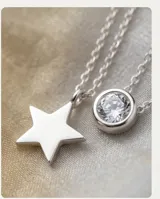 Collar doble de plata 925, compuesto por una cadena fina con un dije de circonia circular y otra cadena con un dije de estrella de plata.