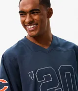 Remera deportiva de manga corta color azul marino, con cuello en V y estampa frontal de los Chicago Bears con numeración en tono blanco. Confeccionada en poliéster con tecnología dry de secado rápido.