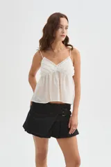Musculosa blanca de lyocell, con tirantes finos regulables, escote en V y detalle de volados en el delantero, de diseño holgado.