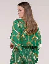 Blusa verde de gasa con transparencia y estampado metalizado dorado, de silueta holgada y mangas cortas. Presenta escote en V con pechera tejida en crochet y apliques de borlas colgantes.