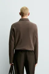 Polo de manga larga con corte regular fit, confeccionado en tejido de algodón con acabado cepillado. Presenta cuello solapa y cierre frontal con botonadura.