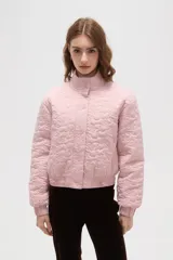 Campera corta de cuello alto, con cierre frontal de botones a presión y puños elásticos. Presenta un diseño acolchado con un patrón floral grabado en toda la superficie.
