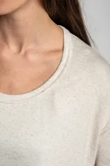 Remera color arena con efecto melange, de corte oversize, cuello redondo y mangas 3/4.