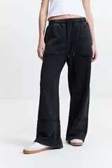 Pantalón de felpa negro con cintura elastizada ajustable, bolsillos laterales y corte acampanado.