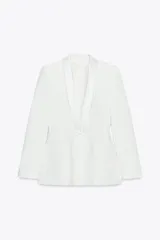 Blazer entallada color blanco, con cuello solapa combinado, manga larga con hombreras, bolsillos de plastrón en delantero, detalle de costuras marcadas, forro interior a tono y cierre frontal con botón forrado en mismo material.