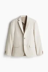 Blazer de lino liviano color beige, con solapas de muesca finas, botonadura sencilla de un botón, bolsillos con solapa en el frente y bolsillo superior ojal.