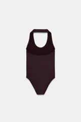 Body de cuello halter confeccionado en tejido rib, con diseño de espalda descubierta y cierre inferior.