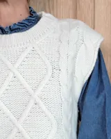 Chaleco de punto gris oscuro con diseño de trenzas y rombos en relieve, cuello redondo y terminaciones acanaladas.