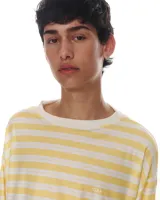 Remera de manga larga confeccionada en viscosa, con estampado de rayas horizontales amarillas y blancas, corte a la altura de la cadera y cuello con puño en algodón.