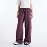 Pantalón de jogging New Balance Trackside holgado de color bordó, confeccionado en felpa francesa de algodón y poliéster. Cuenta con cintura elástica con cordón de ajuste y diseño con bordado y estampado en la pierna izquierda.