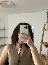 Gargantilla con cordón de cuero marrón y dije plateado en forma de pez koi.