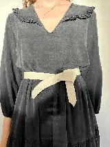 Cinturón de cuero color beige claro, diseñado para atar en forma de lazo sobre la cintura. Es un accesorio simple y elegante.