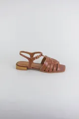 Sandalias de cuero color negro, de suela plana, con tiras entrelazadas en la capellada y tira ajustable en el talón con hebilla metálica.