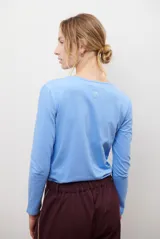 Remera de manga larga con escote en V, confeccionada en algodón de doble capa con textura suave y ajuste al cuerpo.