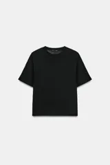Camiseta de cuello redondo y manga corta con hombreras integradas. Presenta un corte regular fit con bajo recto y tejido fluido de lyocell.