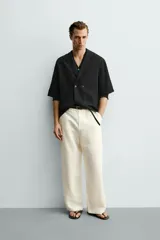 Camisa tipo kimono de corte relaxed fit, color celeste, confeccionada en tejido fluido de viscosa y lino. Presenta cuello con solapas de muesca, manga corta y cierre frontal cruzado con doble botonadura.