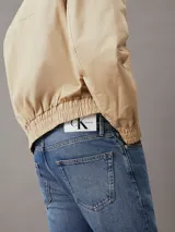 Jeans de denim rígido, lavado azul medio vintage, de tiro alto y corte holgado en la pierna con bajo ligeramente recortado (cropped).