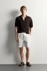 Bermuda de lino negro de corte relaxed fit, con cintura elástica ajustable mediante cordón y bolsillos frontales.