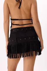 Minifalda negra de gamuza sintética con flecos en el ruedo y doble cinturón con hebillas metálicas.