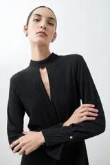 Mono largo negro con textura amasada, cuello mao con abertura en forma de gota, mangas largas y cinturón plateado de eslabones.