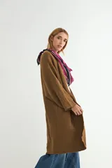 Saco tipo cárdigan largo de tejido de punto, color beige, con diseño abierto sin botones, mangas largas amplias y corte recto.