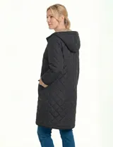 Campera reversible de corte largo con diseño capitoneado. Un lado presenta un tono verde oliva y el otro un tono negro, ambos con cierre frontal mediante botones a presión y bolsillos laterales.