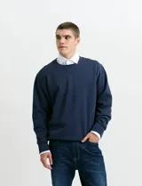 Sweater básico de cuello redondo y manga larga, confeccionado en tejido circular con puños y cuello en tejido canalé.
