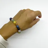 Pulsera elástica con cuentas redondas de cristal de diferentes colores: amatista, cuarzo azul, cuarzo verde, jade amarillo, piedra del sol y cuarzo rosa.