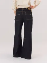 Pantalon de corte ancho y holgado, color verde militar, con diseño de tiro medio, pinzas decorativas debajo de la rodilla, bordado de monograma en el bolsillo delantero y costuras a contratono.