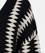Saco de punto negro con estampado geométrico blanco, manga larga amplia y corte alargado.