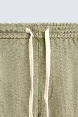Pantalón relaxed fit tejido en hilatura de algodón con estructura, color verde militar. Presenta cintura elástica ajustable con cordón en contraste, bolsillos de vivo frontales y detalle de bolsillo trasero.