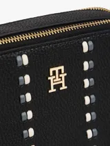 Cartera tipo bandolera de Tommy Hilfiger con acabado granulado, dos compartimentos principales con cierre de cremallera, correa ajustable y detalle de cinta distintiva con monograma TH metálico en la parte frontal.