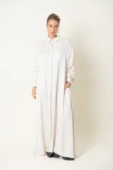 Vestido camisero largo color marfil, de satén de seda, con cuello camisero, mangas largas y bolsillos laterales.