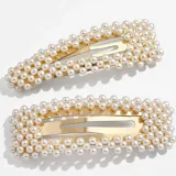 Set de dos broches dorados para el pelo, decorados con perlas sintéticas.