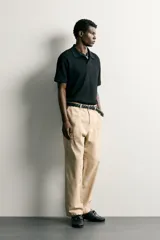 Polo regular fit color blanco, de manga corta con cuello solapa, abertura frontal y acabado en rib con textura de rayas verticales.