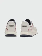 Zapatillas deportivas Boss modelo TTNM EVO, color blanco con detalles en azul marino y rojo. Presentan una combinación de paneles de cuero sintético perforado y malla transpirable, con suela de goma robusta y logo de la marca en el lateral.