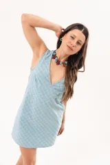 Vestido corto celeste con estampado de cuadros, de silueta recta y sin mangas, con escote en V profundo y recortes en diagonal.
