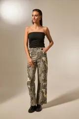 Pantalón de algodón con estampado de piel de serpiente en tonos beige y negro, corte recto y tiro alto.