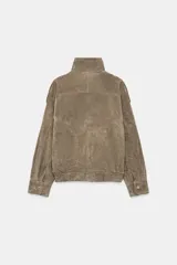 Cazadora de piel gamuzada de color negro, con cuello subido, manga larga con trabillas en los hombros, bolsillos delanteros, bajo elástico y cierre frontal cruzado.