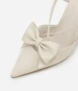 Zapato tipo slingback de punta fina con tacón tipo cono, confeccionado en material sintético con acabado brillante. Presenta un detalle de maxi lazo en la parte frontal y una tira ajustable con hebilla en el talón.