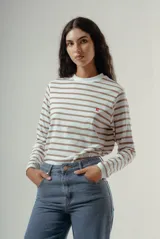 Camiseta de manga larga, cuello redondo, con rayas horizontales marrones sobre fondo blanco. Presenta un pequeño logo bordado en rojo en el pecho.