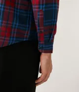 Camisa masculina de franela a cuadros en tonos rojo y azul, de corte comfort, con cuello camisero, manga larga y abotonadura frontal.