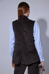 Chaleco de pana color bordó, con cierre frontal de botones y bolsillos laterales.