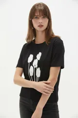 Remera de manga corta color blanco, de corte holgado con cuello redondo a la base y estampado frontal en tono bordó de un gato y un ovni en un paisaje desértico.