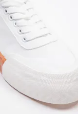 Zapatilla de tela acordonada con punta de goma reforzada y plataforma de 2,5 cm con suela de goma color caramelo.