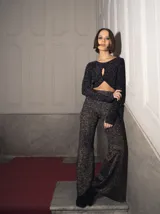 Top negro de tejido de punto con hilado italiano, manga larga con orificio para el pulgar, abertura en el pecho y cordones para cerrar el frente.