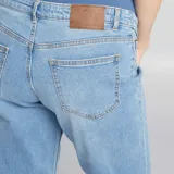 Pantalón de jean celeste de corte recto, con cintura alta elástica para embarazo y ruedo doblado.