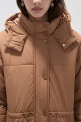 Campera larga tipo parka acolchada color negro, con capucha desmontable, cierre frontal con botones a presión, bolsillos laterales y cordón ajustable en la cintura.